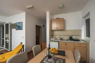 a kitchen and dining room with a table and chairs at Apartments Franićević in Petrovac na Moru