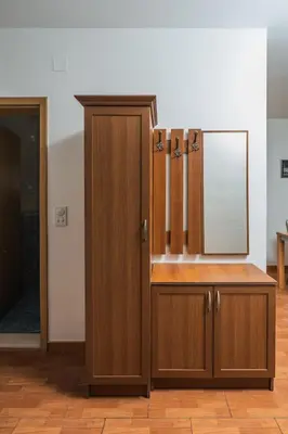 a wooden cabinet with a mirror in a room at Apartments Franićević in Petrovac na Moru