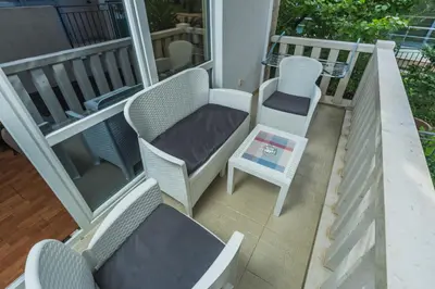 a balcony with chairs and a table and a chair at Apartments Franićević in Petrovac na Moru