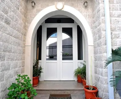 an arched entry door to a home with potted plants at Apartments Franićević in Petrovac na Moru