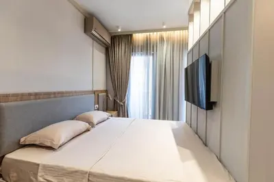 a bedroom with a large bed with a flat screen tv at Hana in Pržno