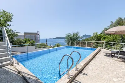 a swimming pool with a view of the water at Hana in Pržno
