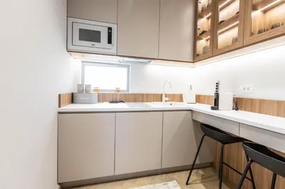 a kitchen with white cabinets and a microwave at Hana in Pržno