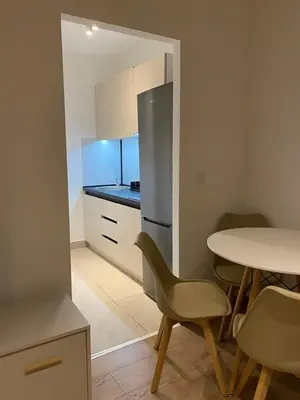 a small kitchen with a table and a refrigerator at Golden Nook in Podgorica