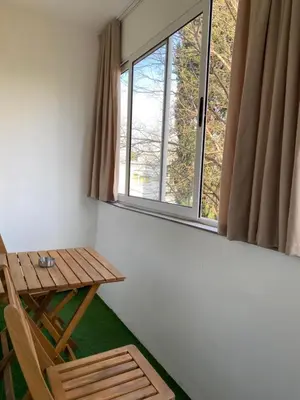 a table and chairs in a room with a window at Golden Nook in Podgorica