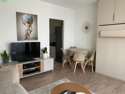 a living room with a flat screen tv sitting on a cabinet at Golden Nook in Podgorica