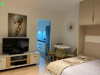 a bedroom with a bed and a flat screen tv at Golden Nook in Podgorica