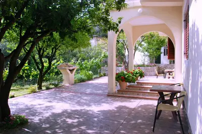 a porch of a house with a table and chairs at Vila Mitrovic in Budva