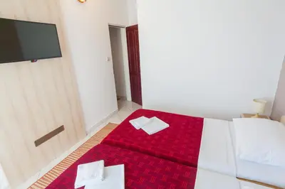 a bedroom with a red bed with two white boxes on it at Vila Mitrovic in Budva