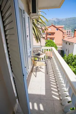 a balcony with a table and chairs on a building at Vila Mitrovic in Budva