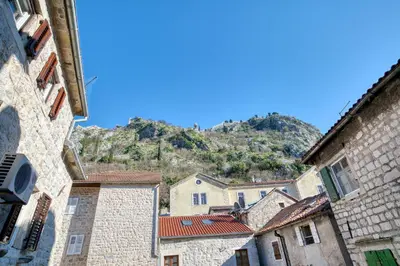 a view of a mountain from between two buildings at Museum Palazzo Suite by MN Property in Kotor