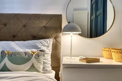 a bedroom with a bed with a mirror and a lamp at Museum Palazzo Suite by MN Property in Kotor