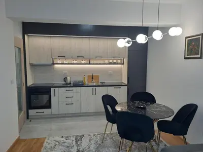 a kitchen with a table and chairs and a counter at Apartman Vlado Podgorica in Podgorica