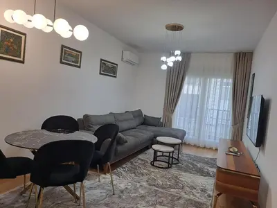 a living room with a couch and a table and chairs at Apartman Vlado Podgorica in Podgorica
