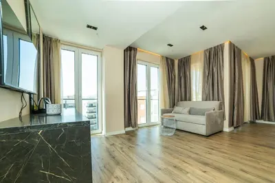 a living room with a couch and some windows at Hotel Umma in Ulcinj