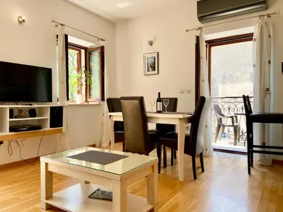 a living room with a table and a dining room at Fiumera Kotor Apartment in Kotor