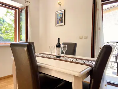 a table with a bottle of wine and two wine glasses at Fiumera Kotor Apartment in Kotor