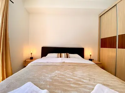 a bedroom with a large bed with two lamps on tables at Fiumera Kotor Apartment in Kotor