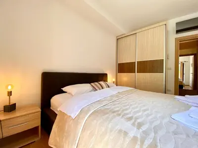 a bedroom with a large bed and a wooden cabinet at Fiumera Kotor Apartment in Kotor