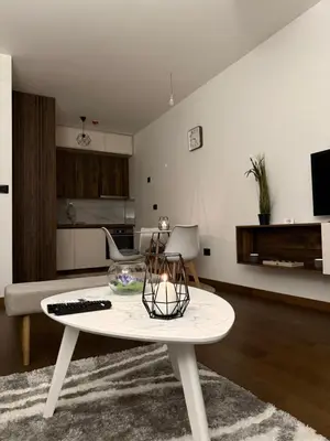 a living room with a table and a living room at Hill Apartment in Podgorica