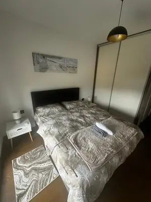 a bedroom with a bed with a comforter on it at Hill Apartment in Podgorica