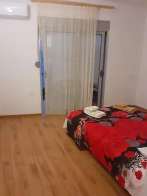 a bedroom with a bed with a red comforter at Apartment Sorelle in Utjeha