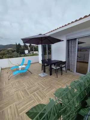 a patio with a table and chairs and an umbrella at Apartment Sorelle in Utjeha