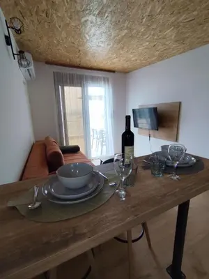 a wooden table with plates and wine glasses on it at Apartment Sorelle in Utjeha