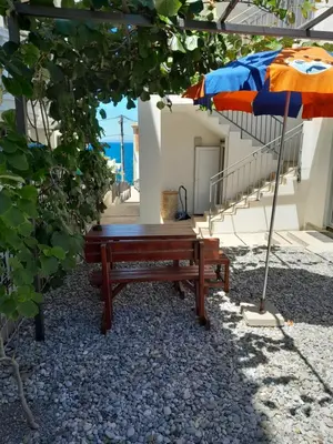 a bench sitting under an umbrella next to a building at Apartment Sorelle in Utjeha