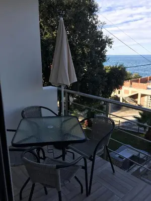 a table and chairs on a balcony with an umbrella at Apartment Sorelle in Utjeha