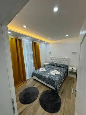 a bedroom with a bed and two rugs on the floor at Eman Villas in Ulcinj