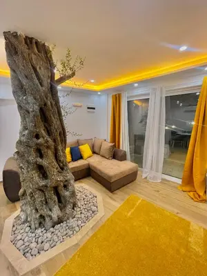a living room with a couch and a tree at Eman Villas in Ulcinj
