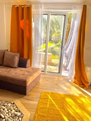 a living room with a couch and a large window at Eman Villas in Ulcinj