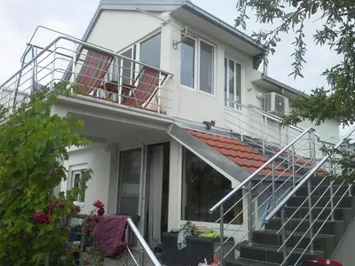 a white house with stairs and a balcony at Apartman Dane utjeha in Utjeha