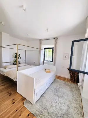 a bedroom with two beds and a large window at Stone Villa at the Vrelo in Dobra Voda