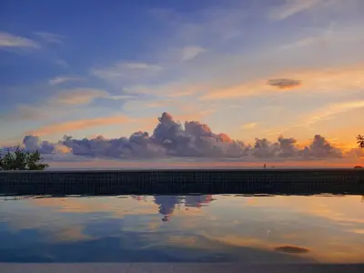 a pool of water with a sunset in the background at Stone Villa at the Vrelo in Dobra Voda