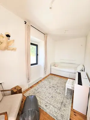a living room with a couch and a piano at Stone Villa at the Vrelo in Dobra Voda