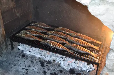 a row of sausages cooking on a grill at Apartments Milosevic in Bar