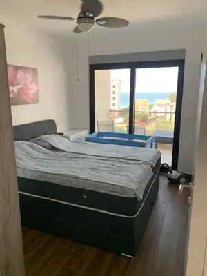 a bed in a room with a large window at Apartmani Beba in Bar