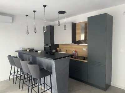 a kitchen with a black counter and bar stools at Vila AS Krimovica in Krimovice