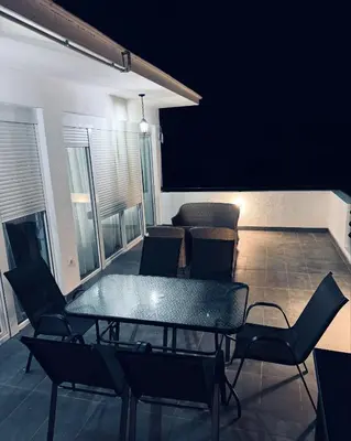 a patio with a table and chairs on a balcony at Vila AS Krimovica in Krimovice