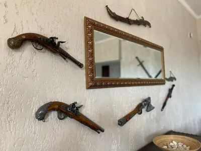 a mirror and some weapons on a wall at Apartments Villa St. Bar in Bar