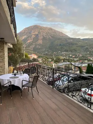 a table and chairs on a balcony with a mountain at Apartments Villa St. Bar in Bar