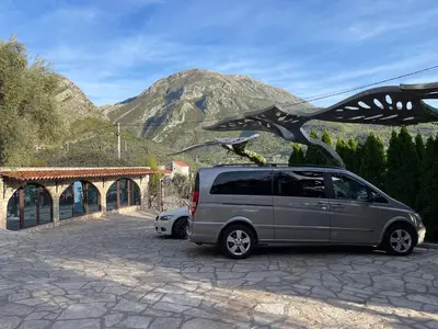 a van parked in a parking lot with a bird sculpture at Apartments Villa St. Bar in Bar