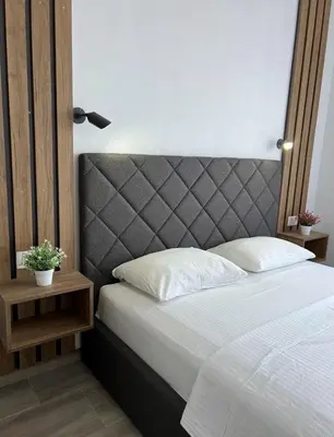 a bedroom with a large bed with a gray headboard at Apartment Complex with Pool in Bar, Montenegro in Bar