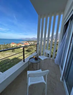 two chairs and a table on a balcony overlooking the ocean at Apartment Complex with Pool in Bar, Montenegro in Bar