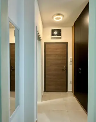 a hallway with a wooden door and a mirror at Tre Sorelle in Podgorica