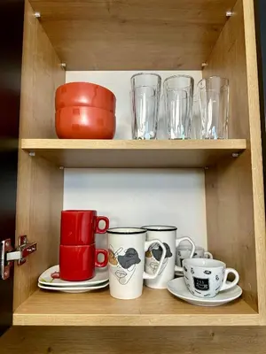 a wooden shelf with cups and plates and glasses at Tre Sorelle in Podgorica