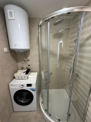 a bathroom with a shower and a washing machine at Tre Sorelle in Podgorica