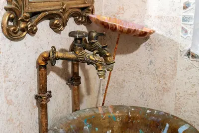 a bathroom sink with a copper faucet and a bowl at Artintime Apartments in Kotor
